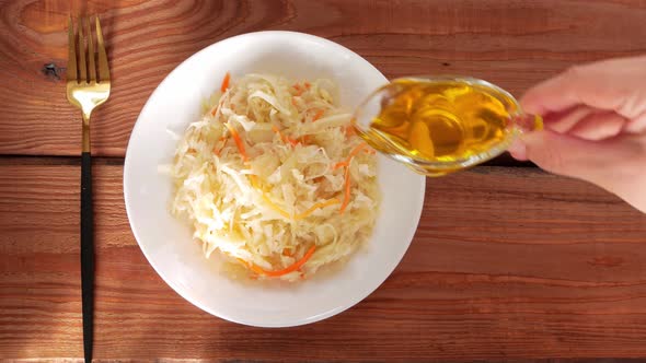 Eating Sauerkraut with vegetable oil. National european dish Pickled cabbage carrot