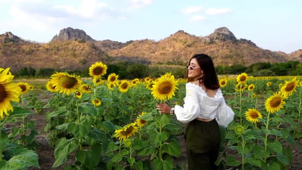 slow-motion of cheerful woman walking and enjoying with sunflower field