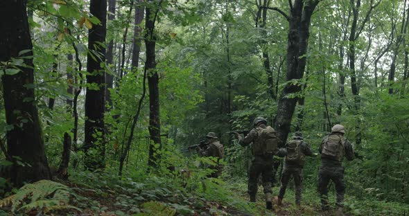 Soldiers Moving Through Forest During Tactical Action Concept of War and Attacking