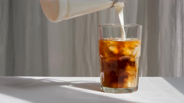Milk Cream is Poured Into a Iced Coffee