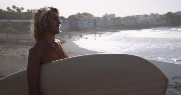 Young blonde surfer man on the beach - Extreme sport concept