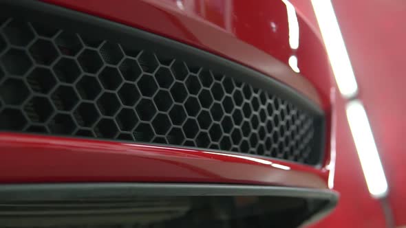 Red, luxury, sport, muscle car bumper detail. Racing automobile shiny hull pan.