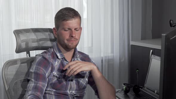 Man Eating Pizza While Working on a Project on His Computer