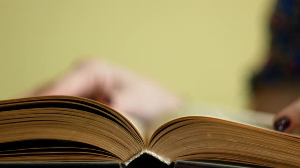 Leisure of a woman reading a book. close-up woman reads and leafs through the pages of an old book