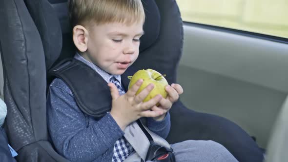 Kid Eating Apple in Car Seat