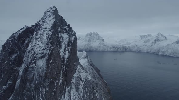 Aerial drone view passing the rocky Segla peak, winter, polar night in Senja, Norway