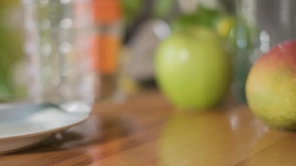 Slices Of Green Apples Falling Into Chopping Board With Water Splashes. - close up, slow motion