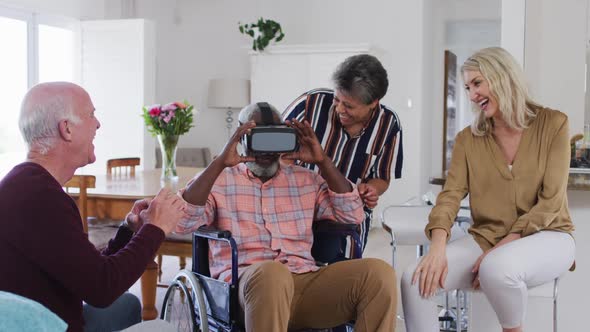 Two diverse senior couples sitting on a couch disabled african american man is using vr googles