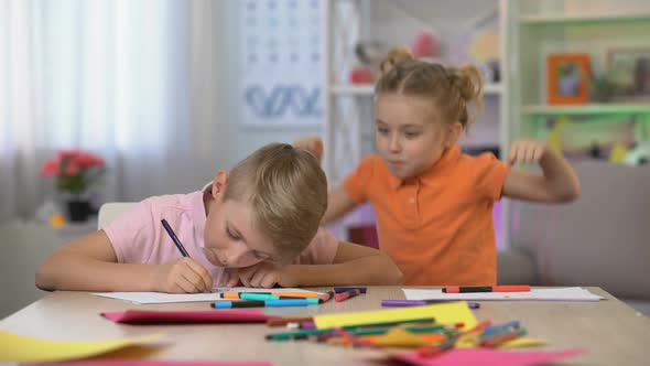 Cute Girl Scaring Brother Studying Table, Child Hyperactivity, Attention Deficit