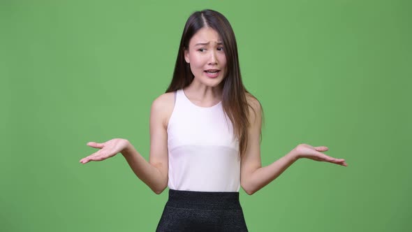 Young Beautiful Asian Businesswoman Shrugging Shoulders