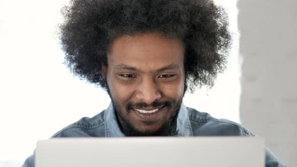 Close Up of Excited Creative African Man Cheering for Success on Laptop