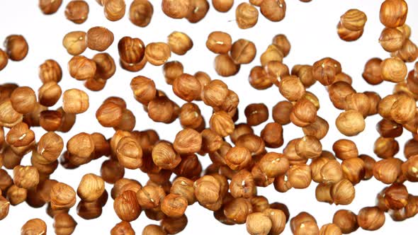 Super Slow Motion Shot of Flying Hazelnuts After Being Exploded on White Background at 1000 Fps.