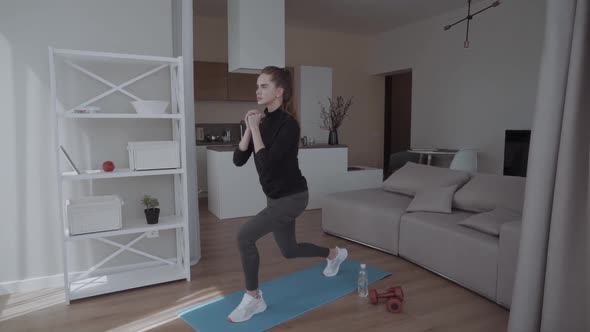 Sporty Young Woman Doing Squat Morning Exercise Alone in Living Room Serious Fit Girl Wearing