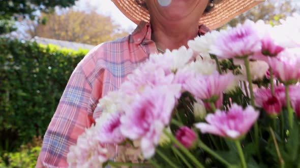 Portrait of happy senior woman holding bunch of flowers 4k