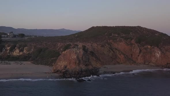 AERIAL: Flight Over Malibu, California View of Beach Shore Line Pacific Ocean at Sunset with