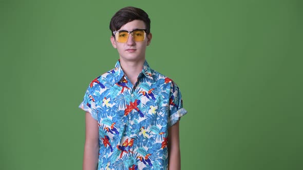 Young Handsome Iranian Teenage Boy Ready for Vacation Against Green Background