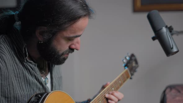 Young Bearded Musician Playing Some Chords to an Online Audience