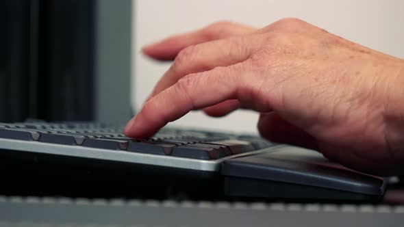 Old Caucasian Woman Works on Computer in Home - Closeup of Hand and Keyboard