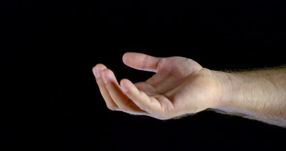 Close - Up of Male Hand Movement with Palm and Fingers on Black Isolated Background