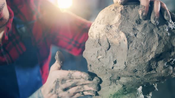 Close Up of a Clay Sculpture with Male Hands Shaping It