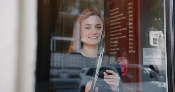 Female Owner Smiling While Turning Sign for Opening of Cafe Waiting for Clients