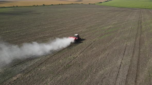 The Tractor Spreads Fertilizer On The Field  