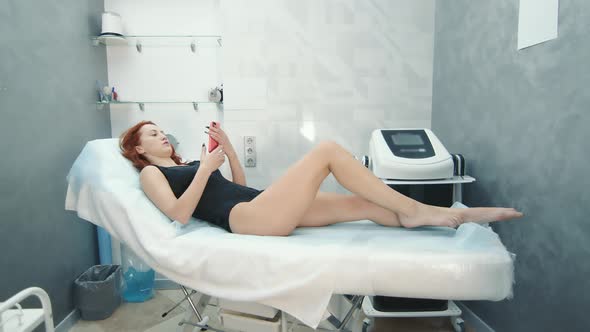 A Woman Is Lying on a Couch in a Beauty Salon and Waiting for a Procedure To Reduce Cellulite