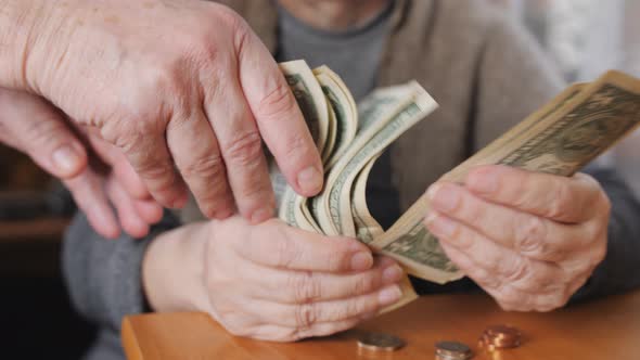 A Woman with Small Bills in Her Hands Counts the Remaining Savings