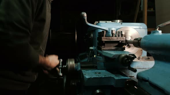 Turner Rotates Metal Lathe Lever and Starts Grinding Part