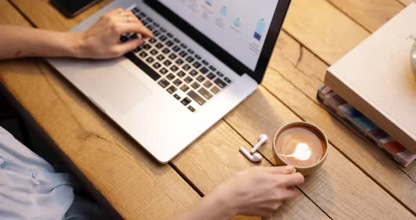 Female Working on Laptop with a Coffee Cup