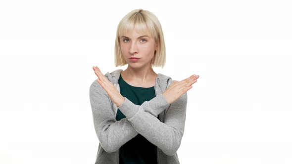 Portrait of Woman with Bob Haircut in Sweatshirt Strictly Gesturing with Hands in Crossed Meaning