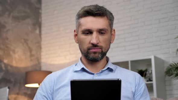 Close Up Smiling Businessman Uses Tablet at Home Office