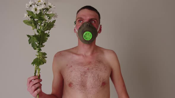 A Faceless Shirtless Man in a Gas Mask with Flowers