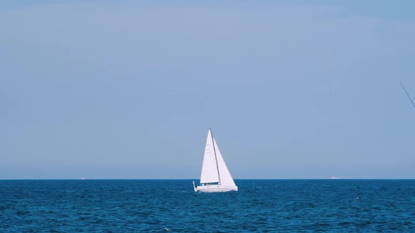 Ship Floating In Sea. Sailing boat with spinnaker sail in open sea