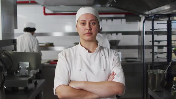 Portrait of caucasian female chef with arms crossed looking at camera