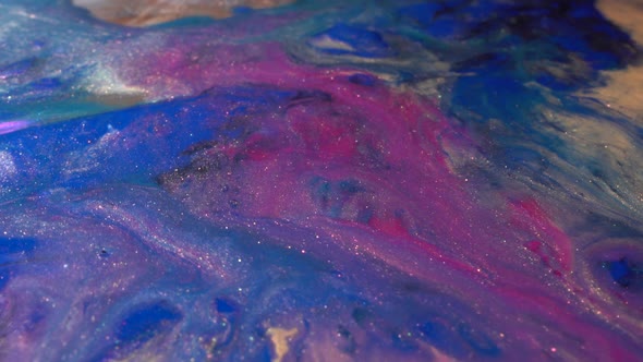 Blue beige and neon pink colors paint mix macro. Acrylic Painting. Glitter ink flow