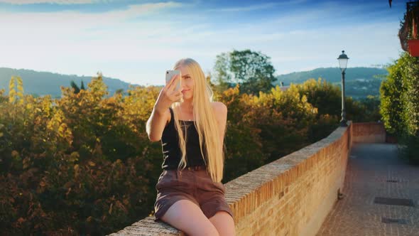 Pretty Girl Making Selfie on Smartphone in Front of Beautiful Nature Landscape