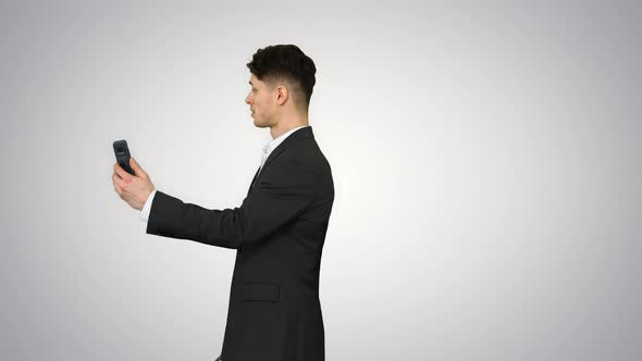 Young Business Man Walking and Taking a Selfie on Gradient Background.