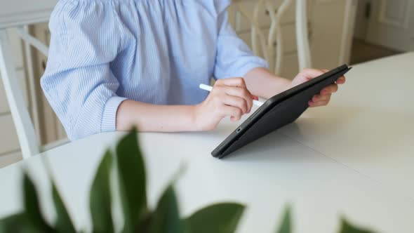 Woman Working on the Tablet Using Pencil in the Light Modern Interior