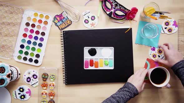 Step by step. Flat lay. Baker getting ready to sketch a design of a cake for Dia de los Muertos holi