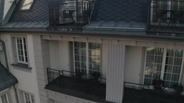 White Wedding Dress Hangs on Special Hanger in Doorway of Balcony of Luxury House Aerial View