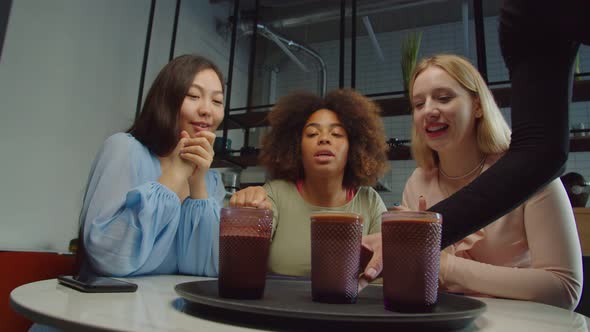 Waitress Serving Coffee to Multiethnic Female Customers at Cafe