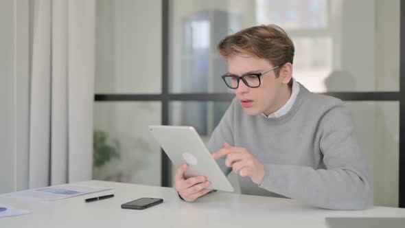 Young Man Reacting to Loss on Tablet While Sitting in Modern Office