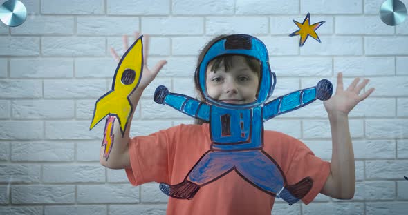 Astronomy at home. A child play with a small space suit from the glass.