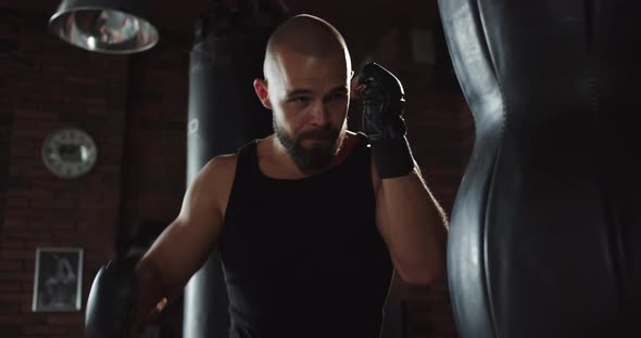 A Boxer Hones His Punching Power on a Punching Bag in the Gym