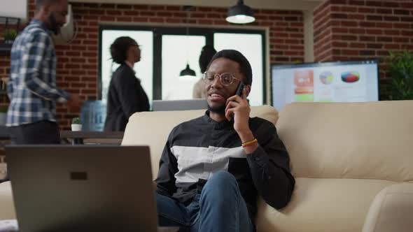 African American Person Chatting on Phone Call in Business Office