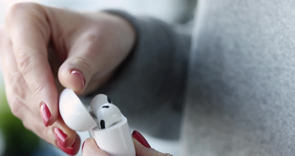 Female Hands Open a Box with White Wireless Headphones