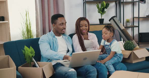 African American Father Showing Funny Video on Laptop to His Cute Small Daughter