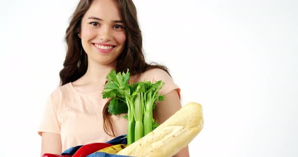 Portrait of smiling woman holding a grocery bag