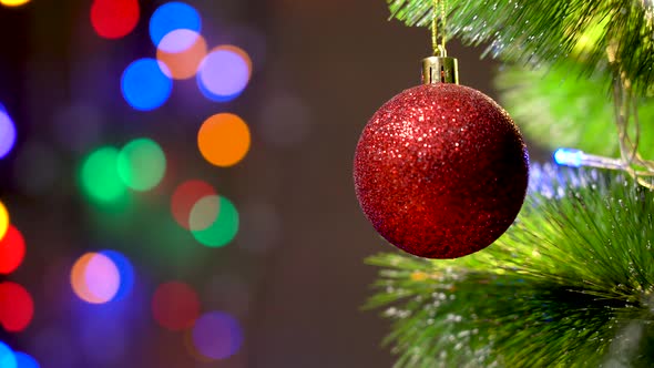 Red Matte Ball on the Christmas Tree Close-up. Magical Fabulous Bokeh. Christmas Holidays